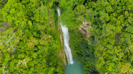 Aerial top view jungle Waterfall in a tropical forest surrounded by green vegetation. Mantayupan Falls in mountain jungle. Philippines, Cebu.