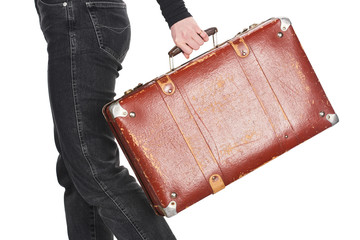 cropped view of woman in jeans holding vintage weathered suitcase isolated on white
