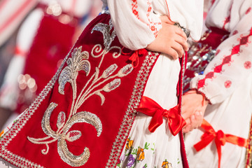 Fototapeta na wymiar Close up of young Romanian dancers perform a folk dance in traditional folkloric costume. Folklore of Romania