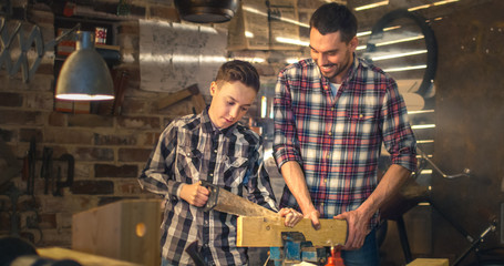Father and son are woodworking in a garage at home.