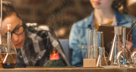 Close-up Shot of a Small Chemistry Volcano. Young boy and girl are making chemistry experiments in a garage at home.
