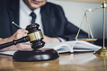 Professional Male lawyer or judge working with contract papers, documents and gavel and Scales of...