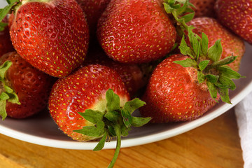 untreated berries of garden strawberry on a plate close-up