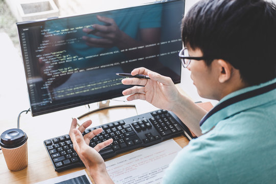Young Professional programmer working at developing programming and website working in a software develop company office, writing codes and typing data code, Programming with HTML, PHP and javascript