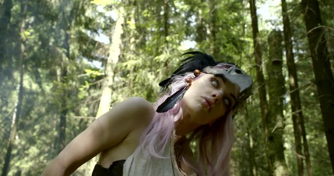 girl shaman in bone mask with black feathers feels spirits