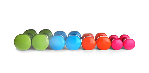 Many colorful dumbbells on white background. Fitness equipment