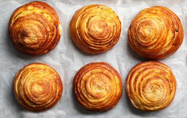 Tasty buns on parchment, flat lay. Fresh from oven
