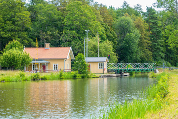 Obraz premium Idyllic cottage by a canal and a road bridge
