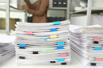 Stacks of documents with paper clips on office desk