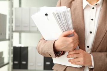 Female worker with documents in archive, closeup