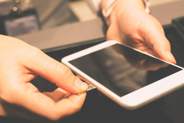 Employees are putting nano-SIM cards in the store for customers to buy women hands.