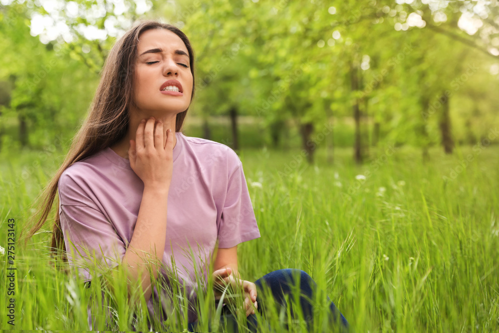 Wall mural young woman scratching neck outdoors, space for text. seasonal allergy