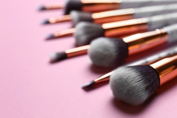 Obraz na płótnie Canvas Different makeup brushes on pink background, closeup. Space for text