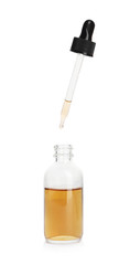 Essential oil dripping from pipette into glass bottle on white background