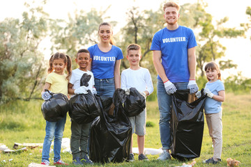 Volunteers with kids collecting trash in park