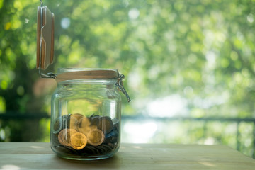 Thai Baht coins in a glass jar