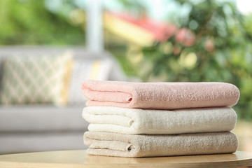 Stack of folded clean soft towels on table indoors