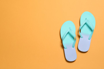 Bright flip flops on color background, top view with space for text. Beach accessories