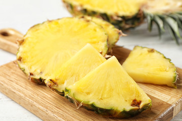 Cut fresh juicy pineapple on wooden board, closeup