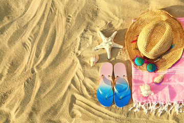 Fototapeta na wymiar Flat lay composition with stylish beach accessories on sand. Space for text