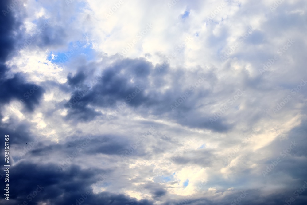 Wall mural dark cloud formations forming before a storm on a blue sky