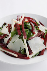 A delicious fresh and healthy salad of Apple, Beetroot,spinach and Parmesan Cheese (Parmigiano-Reggiano) isolated on a white dish and clean background.