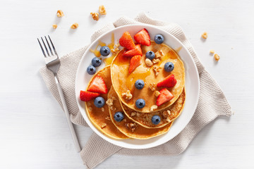 pancakes with blueberry strawberry honey and nuts for breakfast - obrazy, fototapety, plakaty