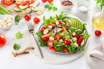 greek style avocado tomato salad with feta cheese, olives, cucumber, onion, lettuce