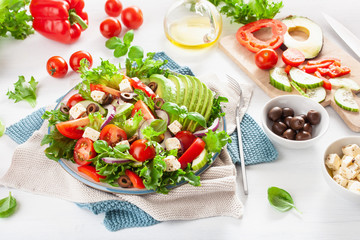 greek style avocado tomato salad with feta cheese, olives, cucumber, onion, lettuce