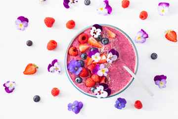 healthy summer berry smoothie bowl with flowers and chia seed