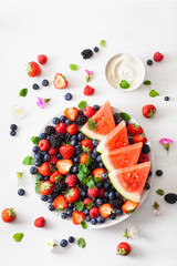 fruit and berry platter over white. blueberry, strawberry, raspberry, blackberry, watermelon