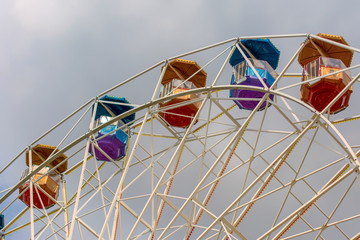 Ferris wheel in the amusement Park with storm gray clouds in the sky.