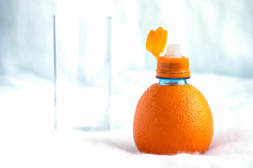 A bottle made of natural orange with an open neck is prepared to pour fresh juice into a tall glass.