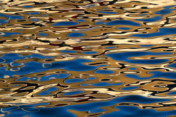 Golden reflections on the sea surface at sunset. Selective focus.