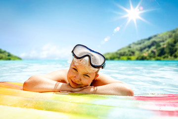 Small young girl with pontoon on sea and summer sunny day. 