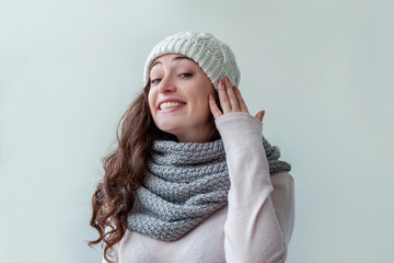 Beautiful woman winter portrait, true emotions. Laughing girl with long hair wearing warm clothes hat scarf isolated on white background. Young hipster girl looking happy and excited, having fun
