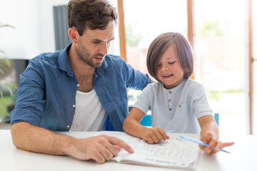 Father and son doing homework together at home