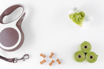 walking equipment, poop bags with leash and dog treats on white background