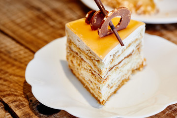 Homemade puffed caramel honey cake on white plate. Photo of holiday dessert for menu of confectionery restaurant