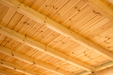 Construction of a wooden roof with wooden beams. Wood ceiling element