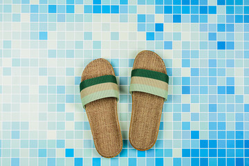 Sandals on blue ceramic tiles at the pool. - Summer holiday concept.