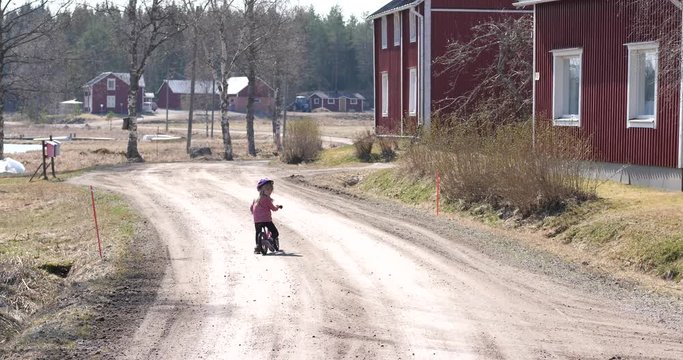 Child riding bike on a lonely road, rural depopulation, growing up in the outskirts