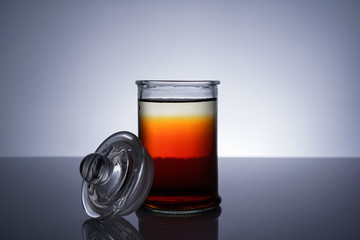 A jar with golden liquid on white background