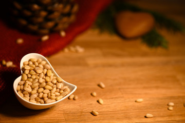 Pine nuts and cones on wooden table with copy space