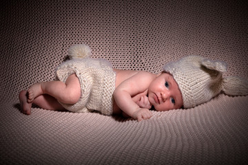 Neugeborenes Baby im Hasenkostüm blickt süß