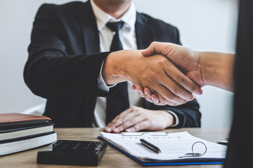 Broker and client shaking hands after signing contract approved form