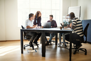 Designers having a meeting together around an office table