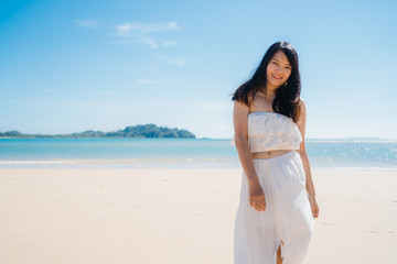 Fototapeta na wymiar Beautiful young Asian woman happy relax walking on beach near sea. Lifestyle women travel on beach concept.