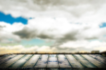 Old vintage wooden board in perspective, against the background of a blurred sky. The template can be used to display your products and advertisements.