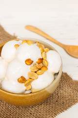 Coconut ice cream with nuts in small bowl with copy space